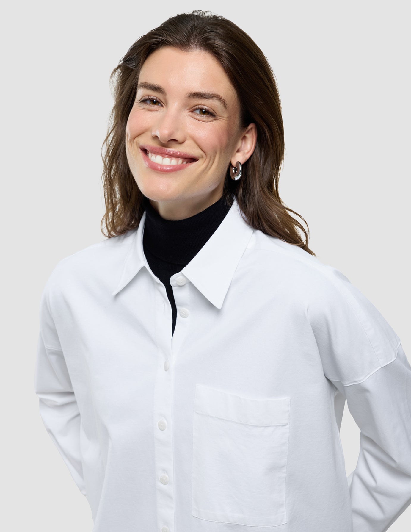Oversized Long Sleeve Shirt i Off White, halvfigur af kvinde iført hvid skjorte med sort rullekrave.